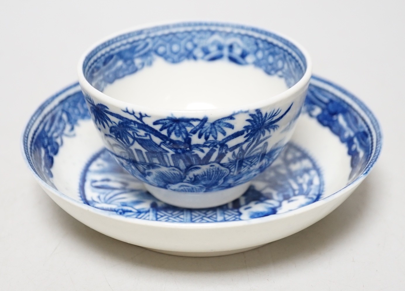 An 18th century Caughley teabowl and saucer printed with the uncommon Fence and House pattern. 6cm tall overall